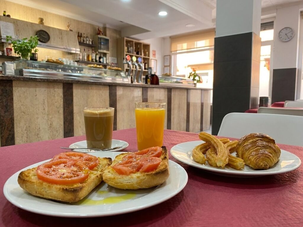 Desayuno español completo con tostadas, café con leche y zumo en La Nueva Dama, El Altet